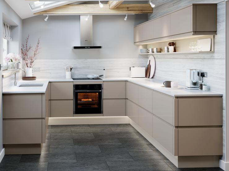 U shape handleless pebble grey gloss kitchen with white worktop and undermount kitchen sink and dark grey flooring.