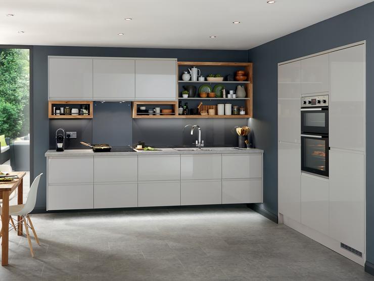Handleless gloss grey kitchen featuring full height kitchen units set recessed into the wall with built in double oven.