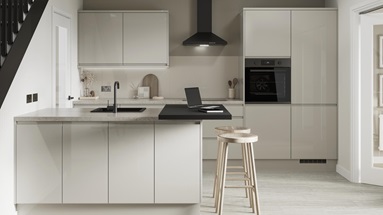 A minimal sandstone kitchen design with gloss, integrated handle doors and matt black features, such as a tap and extractor.
