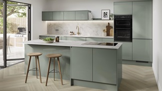 Gloss green kitchen with an island in the centre of the room. There are white marble-effect worktops and herringbone flooring