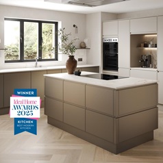 Handleless bronze kitchen with white worktops, chevron flooring and an island in an L-shape. Winner of an Ideal Home Award