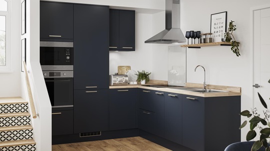 L-shaped compact kitchen layout with navy kitchen doors, wood worktops and wood flooring. Has open shelving and wall units.