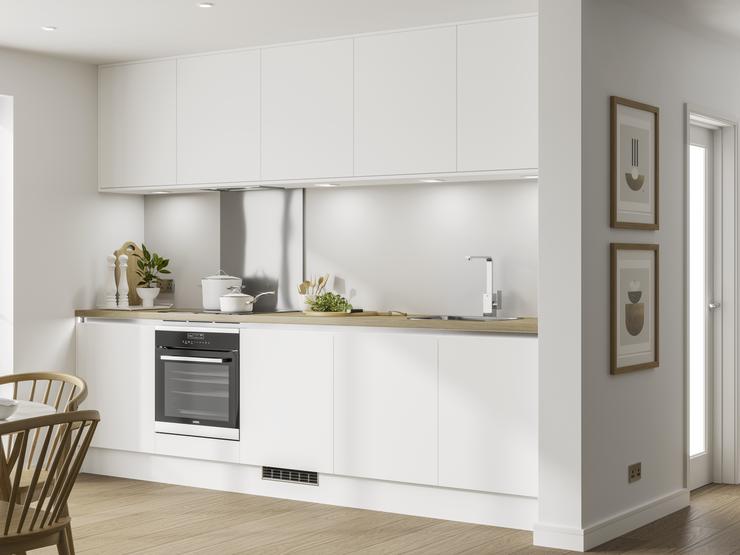 White matt handleless kitchen in single wall layout with under cabinet lighting, wood worktop and built under electric oven.