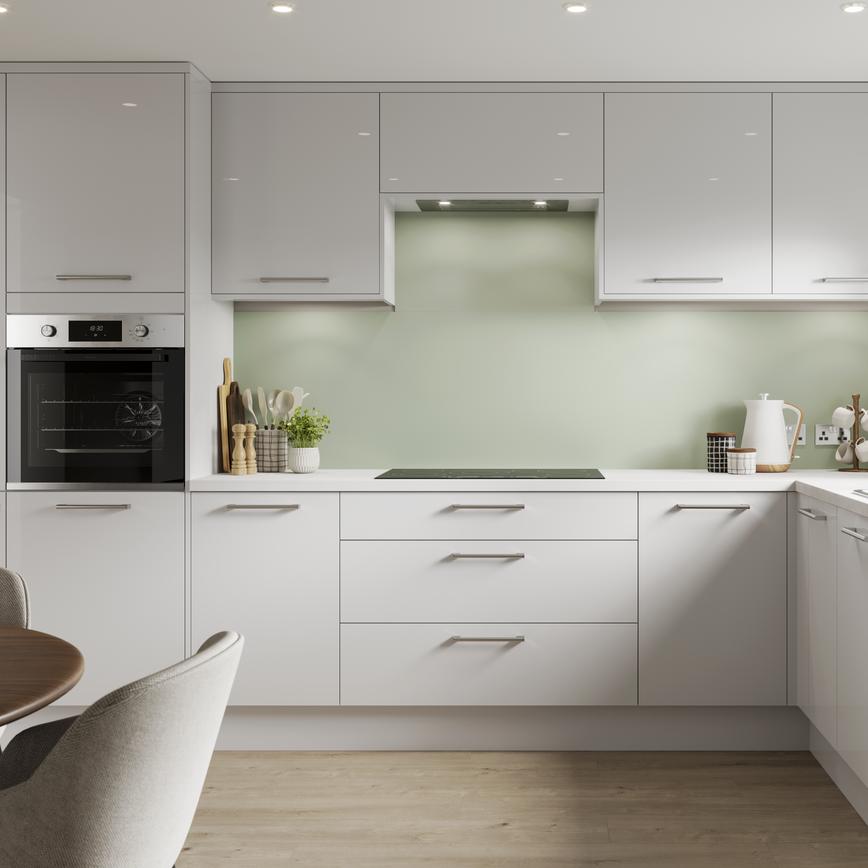 A dove grey kitchen in a gloss finish and in an L-shaped layout. It has integrated appliances and light-oak flooring.
