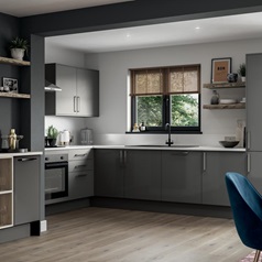 A small l-shaped kitchen using white slab doors in a glossy finish. Has white handles and worktops, and a built-under oven