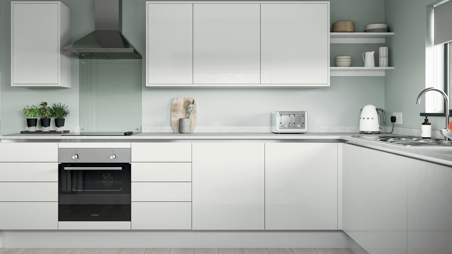 White l-shape kitchen with slab cupboards, white worktops, induction hob, and silver trims for an on-trend handleless look.