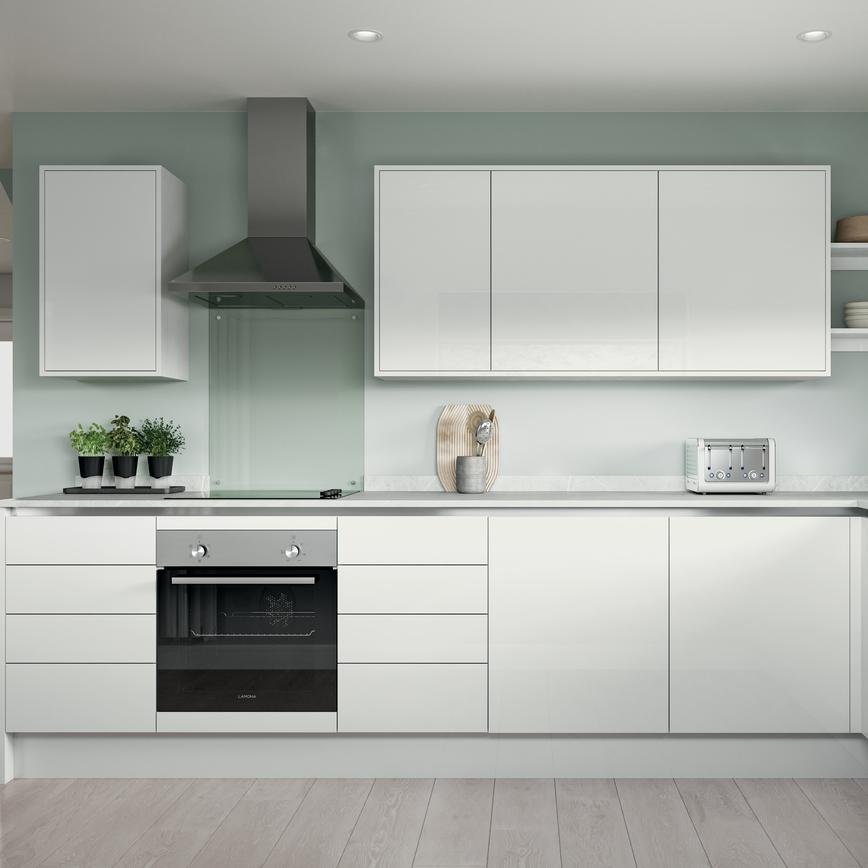 White l-shape kitchen with slab cupboards, white worktops, induction hob, and silver trims for an on-trend handleless look.