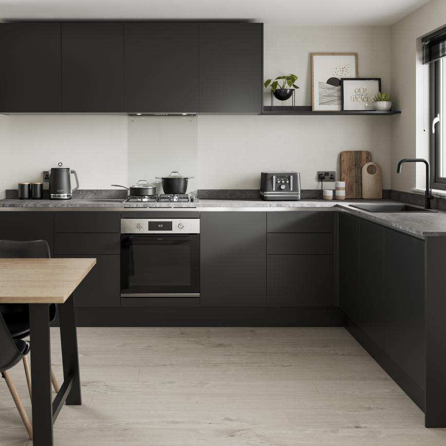 Sleek, modern black kitchen with handleless cabinetry, wall-mounted cupboards, and a grey worktop in an l-shape layout.
