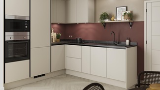 A modern sandstone kitchen design with matt, integrated handle doors, tower devices, black profiles, and a matt black tap