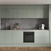 A single wall reed green kitchen, in a gloss finish. It has handleless doors, dark stone backsplash, and dark oak flooring.