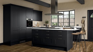 Industrial black shaker kitchen in an island layout, containing a black hob, timber floors, and square-edged white worktops