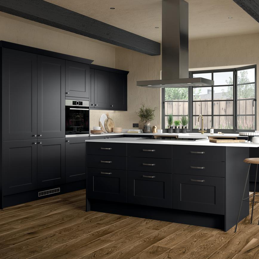 Industrial black shaker kitchen in an island layout, containing a black hob, timber floors, and square-edged white worktops