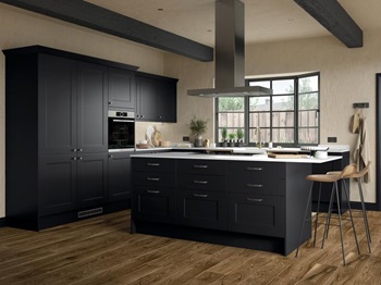 Industrial black shaker kitchen in an island layout, containing a black hob, timber floors, and square-edged white worktops