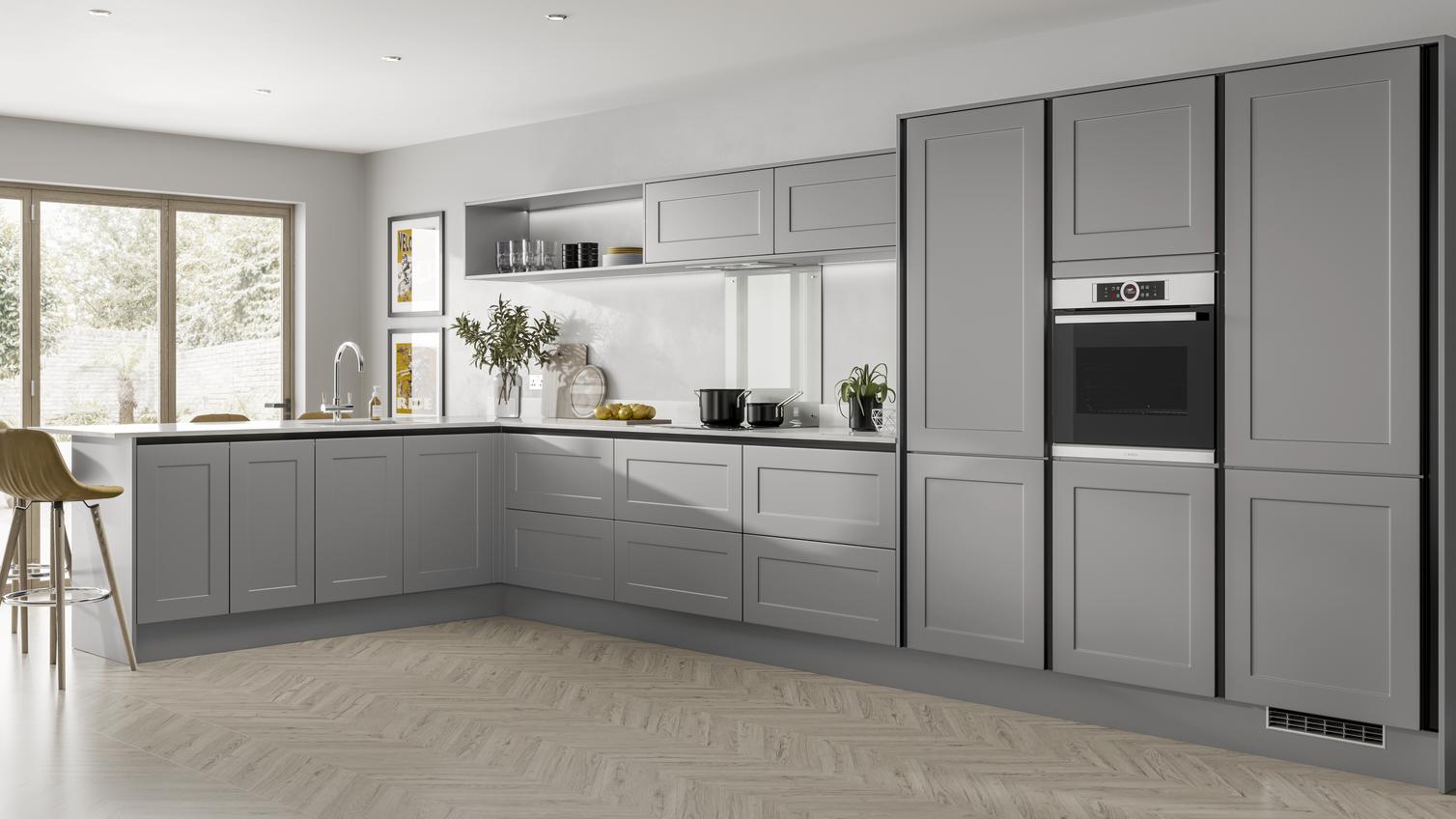 Modern L shaped slate grey shaker kitchen  with breakfast bar overhang, half height wall units and built in oven