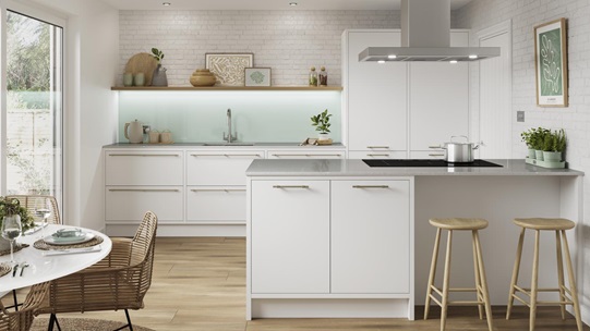 A white slab kitchen with in-frame cupboards in an island layout. Includes black worktops and handles for a monochrome look.