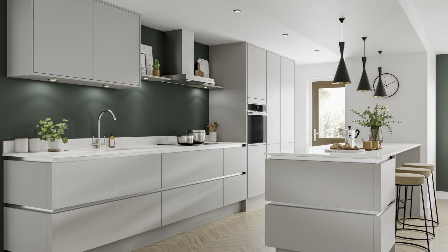 Modern kitchen in dove grey with handleless kitchen doors and cabinet lighting. Breakfast bar with black pendant lights over.