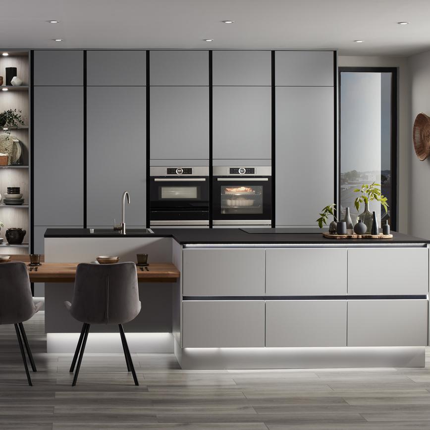 Super matt slate grey handleless kitchen with p shaped kitchen island unit, black kitchen worktop and integrated black trims.