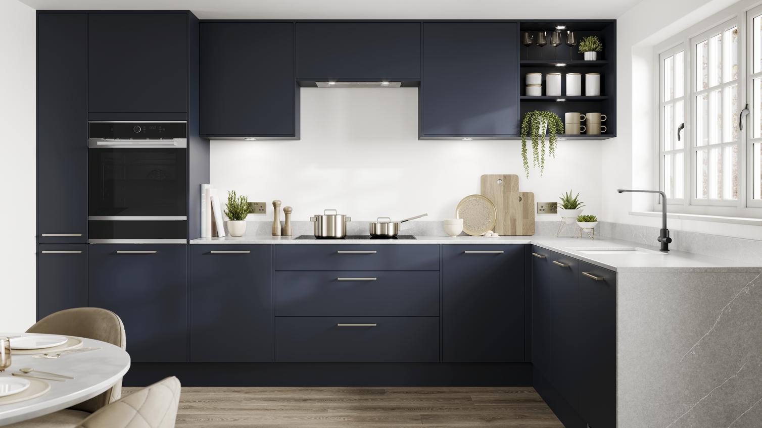 Contemporary blue kitchen idea with super-matt slab doors in a L-shaped layout. Has white marble worktops and brass handles.