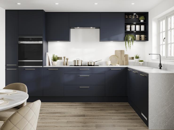 Contemporary blue kitchen idea with super-matt slab doors in a L-shaped layout. Has white marble worktops and brass handles.