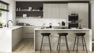 Contemporary kitchen in an island layout with neutral slab doors in a glossy finish. Contains white worktops and a black tap.