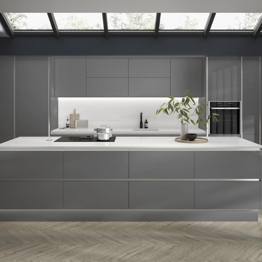 Slate grey handleless kitchen with large kitchen island, downdraft cooker hood, black kitchen tap and built in oven.