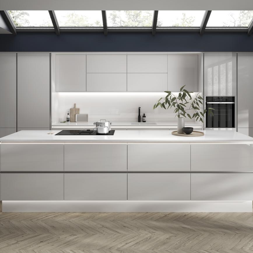 Modern dove grey handleless kitchen with kitchen island featuring downdraft cooker hood, large drawers and white worktop.