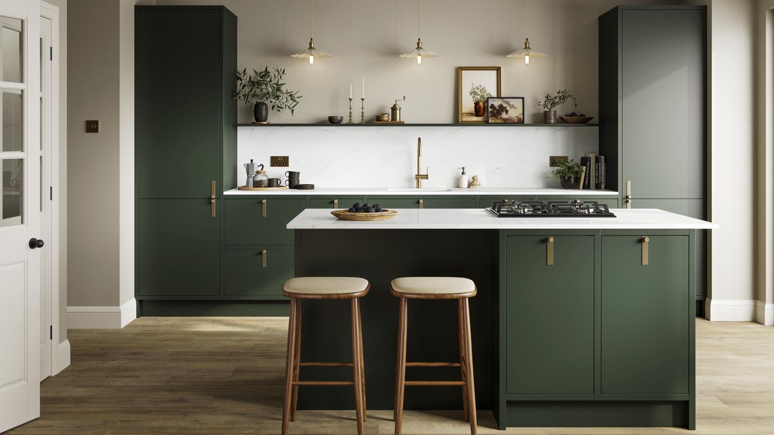 A dark green kitchen with matt cabinets, brass door handles, and a kitchen island complete with a gas hob.