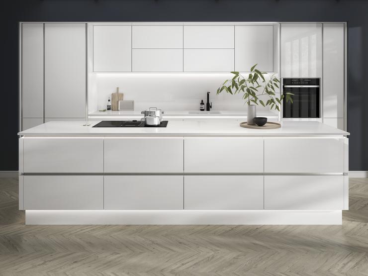 Open-plan white gloss kitchen idea with a linear design. Has white worktops and silver decorative trims for a modern feel.