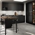 A kitchen with black cabinets and matching counter tops, including a dark wood-effect breakfast bar.