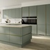 Pale, reed green kitchen in an island configuration in a matt finish. Includes handleless cabinets with brushed nickel trim.