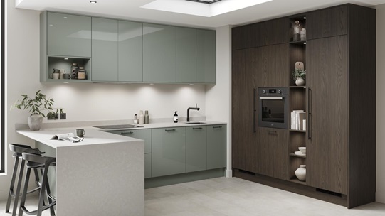 A peninsula kitchen in a gloss reed green finish. It has stone tiled flooring and larder units in a textured walnut effect.