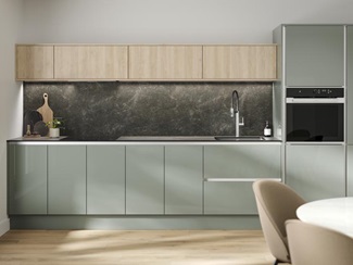 A handleless kitchen in a gloss finish and reed green colour. It has textured oak wall cabinets and black quartz splashback.