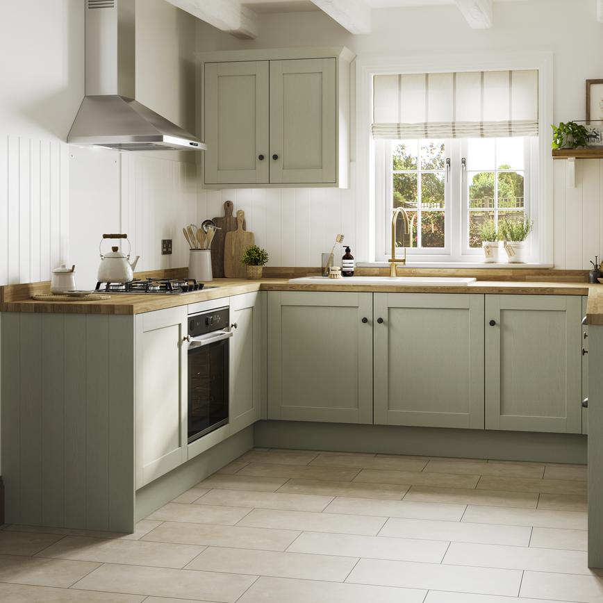 Sage green kitchen with shaker cabinet doors. It is in a u-shaped layout with a gas hob and timber-effect worktop