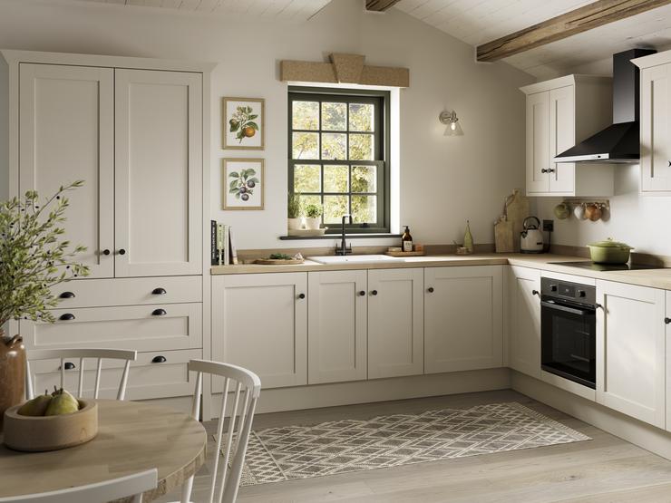 A white, shaker kitchen from the Halesworth porcelain range. It is in an l-shaped layout and features curved cabinet doors