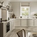 L-shaped, shaker kitchen in a cream, pebble colour. From the Halesworth range. Features white worktops and oak flooring