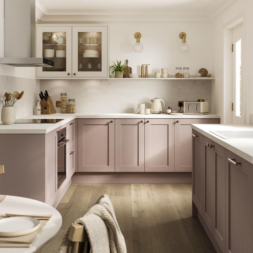 A pink kitchen idea with antique-rose cupboards in a shaker design. Has white wall units and worktops, plus open shelving.