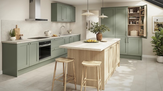 A shaker kitchen in a reed green colour, with wall units and larder cabinet. An oak-colour kitchen island is in the middle.