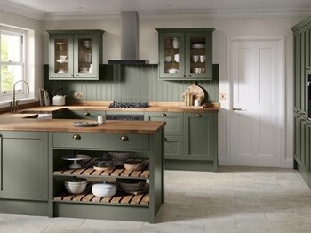 A shaker kitchen in a dark ash green colour and a peninsula layout. There is matching wall panelling and pale oak worktops.