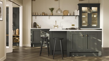 A green shaker kitchen from Ilfracombe Ash Green. It has a kitchen island, glass cabinets, and marble-style worktops.