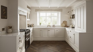 A cream shaker kitchen from Ilfracombe Linen, in a u-shaped layout. It has dark oak herringbone flooring and marble worktops