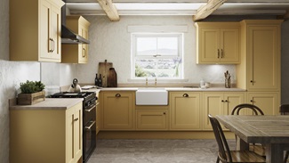 A yellow shaker kitchen from Ilfracombe Saffron, in an l-shaped layout. With wall cabinets, stone floors, and solid worktops