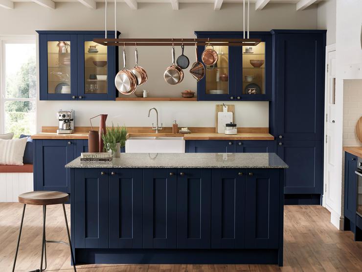 Country living styled blue navy shaker kitchen and island with traditional ceramic double belfast sink and glass cabinets.