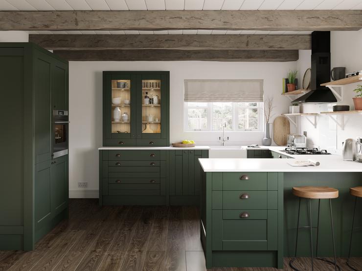 Dark-green kitchen idea in a peninsular layout. Farmhouse shaker-style cupboards with white worktops and dark wood flooring.