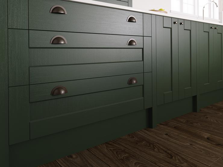 Dark-green kitchen base units, with shaker style cupboards and drawers. Showing pewter cup handles and a thin white worktop.