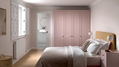 A Halesworth bedroom with pink, antique rose wardrobes & bedside table. It has oak flooring & pocket door to an en-suite.