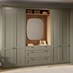 Shaker-style bedroom units in a pale, ash green colour. The tall cabinets feature a desser with drawers and rounded mirror.