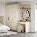 A large bedroom with sandstone cream wardrobe doors in a gloss finish. There is a matching vanity unit with rounded mirror.