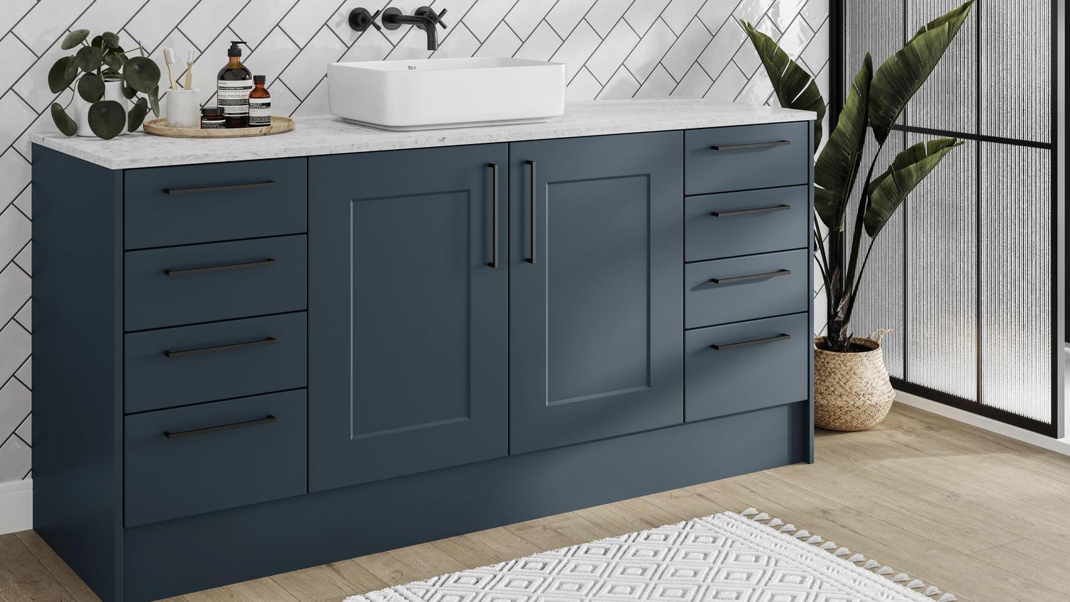 A marine blue bathroom with shaker cupboards in a single wall layout. Includes black bar handles for a sleek, statement look.