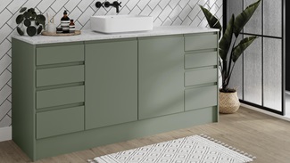 A Clerkenwell bathroom with green cabinets, marble worktop, and black accessories. Also features grey oak flooring.