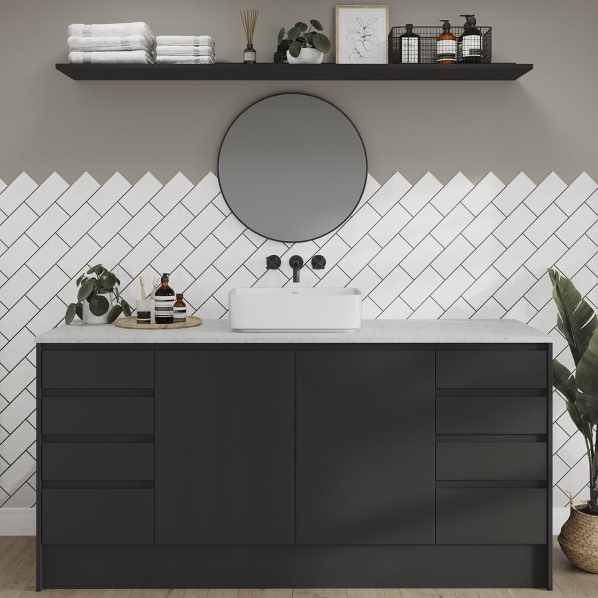 A modern bathroom idea featuring black, integrated handle cupboards. It includes white worktops, tiles, and timber floors.